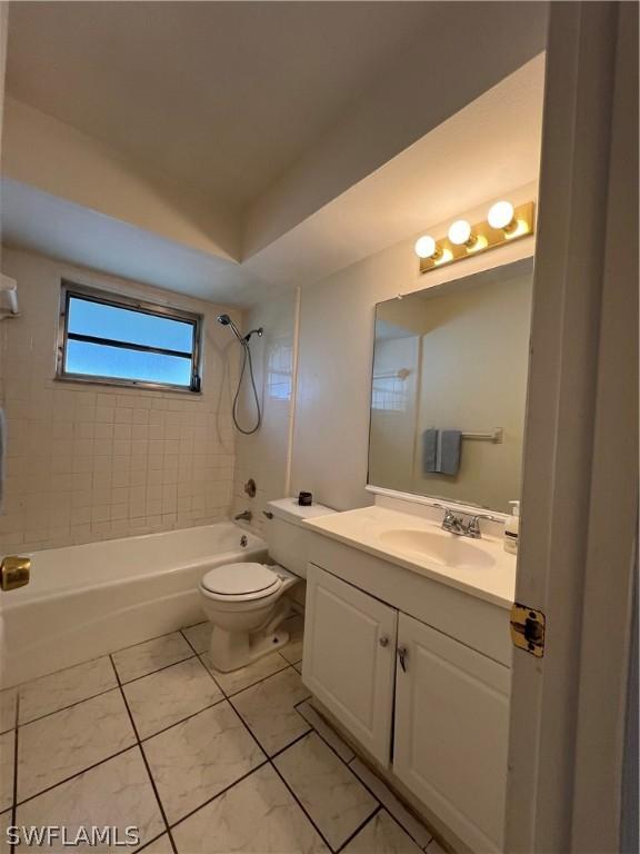 full bathroom with tile patterned floors, tiled shower / bath combo, toilet, and vanity