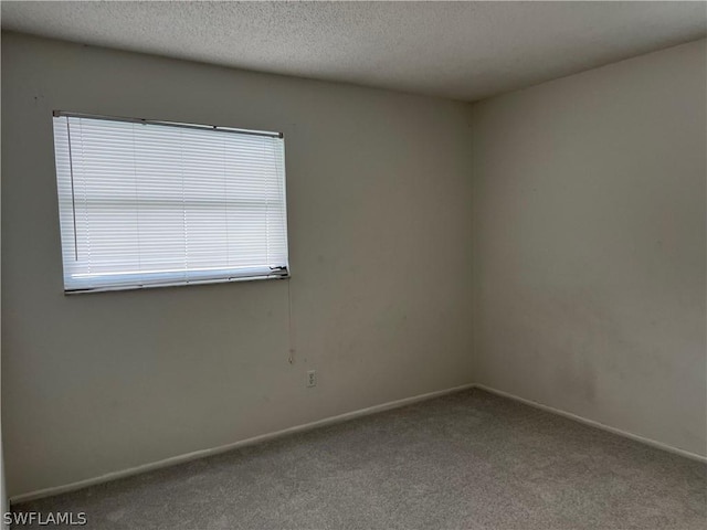 carpeted empty room featuring a textured ceiling