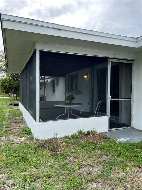 rear view of property featuring a sunroom