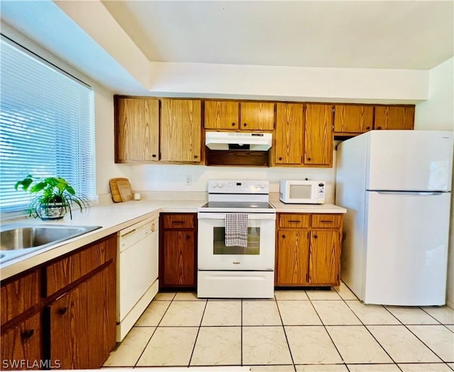 kitchen featuring sink, white appliances, and light tile patterned flooring