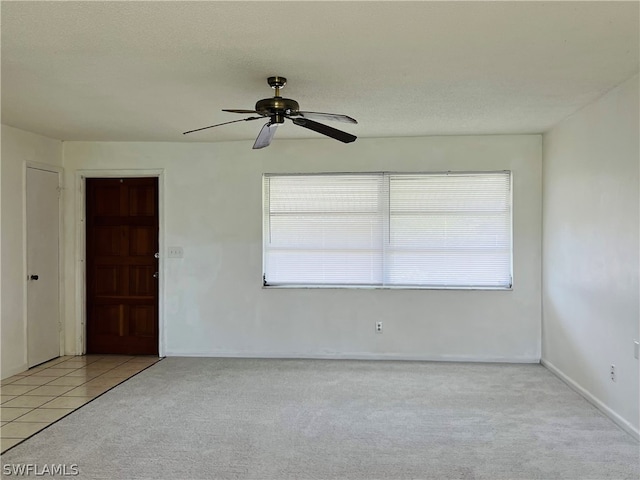 empty room featuring ceiling fan and light tile patterned flooring