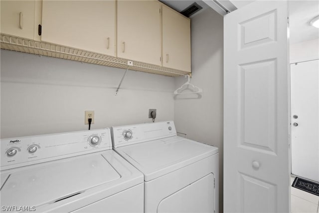 laundry room featuring cabinets and washer and clothes dryer