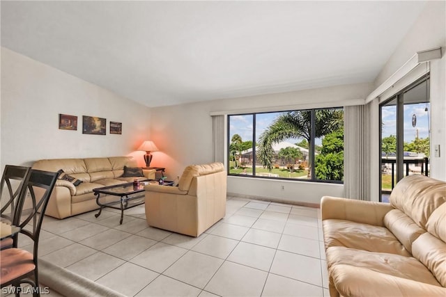 living room with a wealth of natural light, lofted ceiling, and light tile patterned flooring