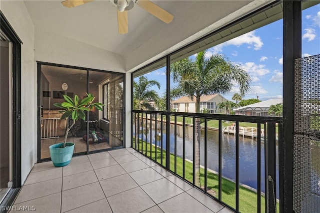 sunroom / solarium featuring ceiling fan and a water view