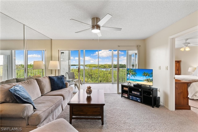 living room featuring a wealth of natural light, ceiling fan, and carpet floors