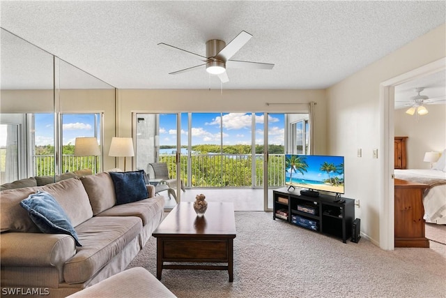 living room featuring ceiling fan, a textured ceiling, and carpet flooring