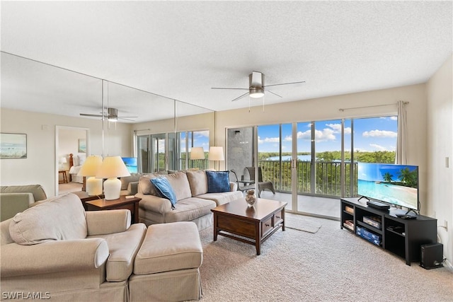 carpeted living room with ceiling fan and a textured ceiling