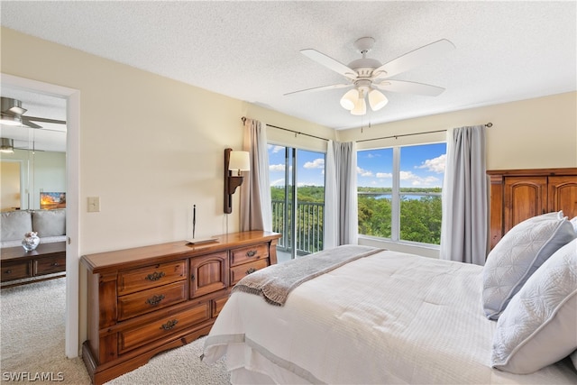 bedroom with a textured ceiling, ceiling fan, carpet floors, and access to outside