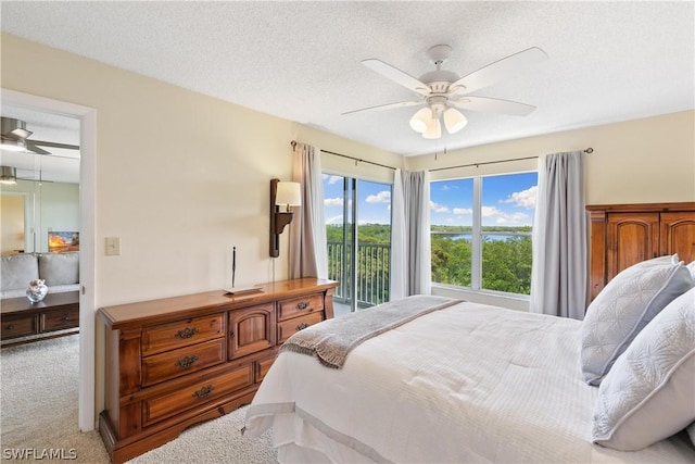 bedroom with access to exterior, a textured ceiling, ceiling fan, and carpet flooring