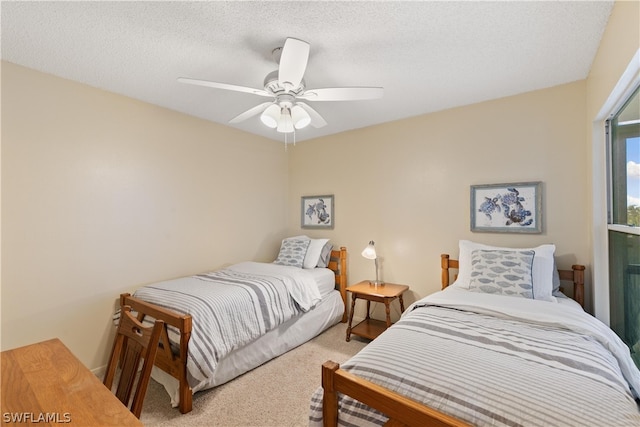 bedroom with a textured ceiling, ceiling fan, and light colored carpet