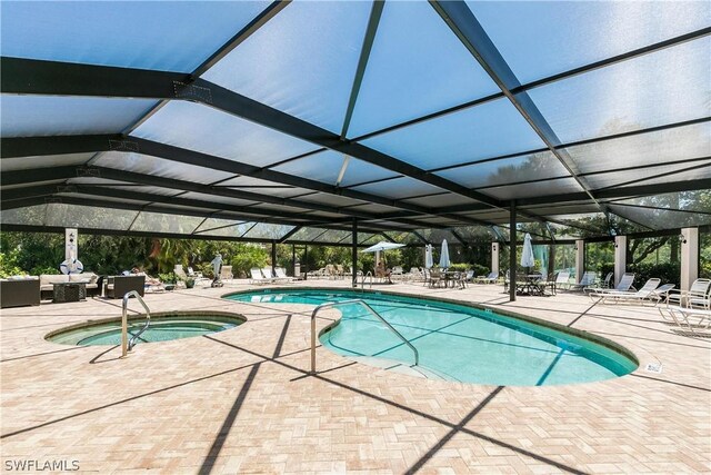 view of swimming pool featuring a patio, a lanai, and a community hot tub