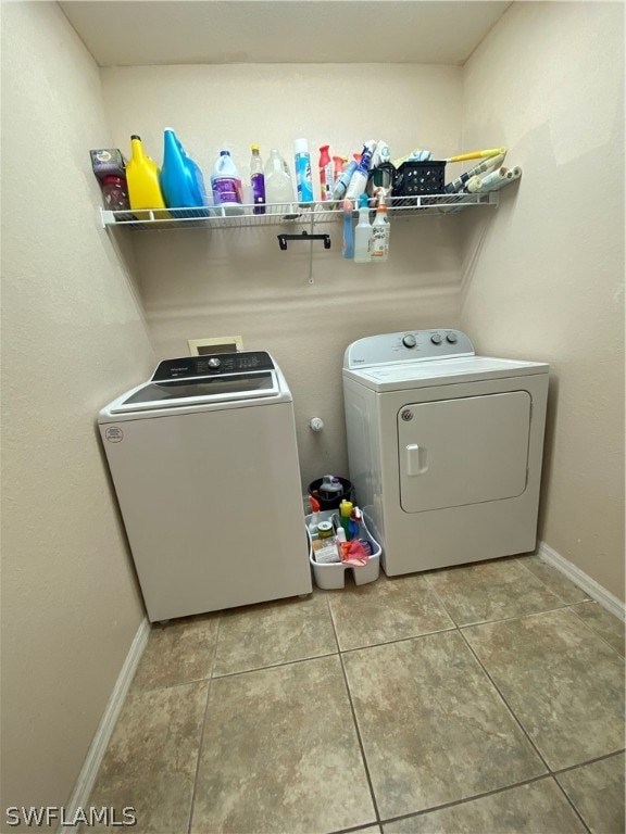 washroom with washer and clothes dryer and tile patterned flooring