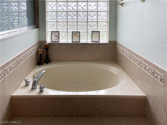 bathroom with a washtub and tile walls