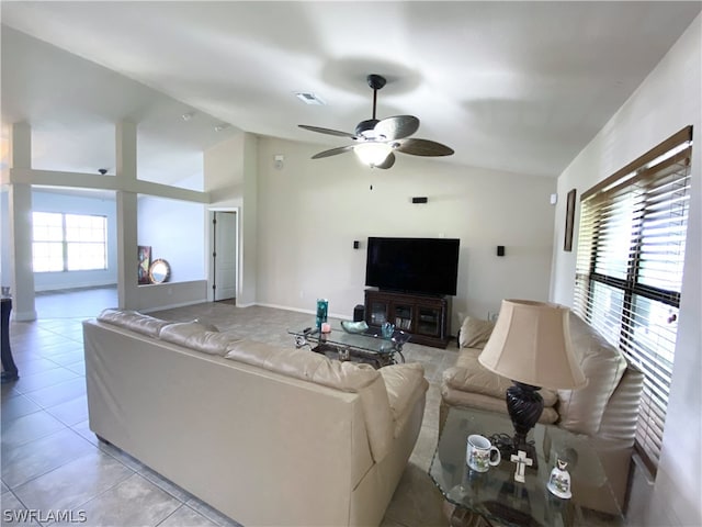 tiled living room featuring vaulted ceiling, a wealth of natural light, and ceiling fan