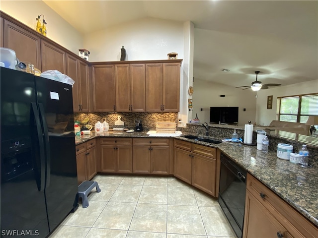 kitchen featuring dark stone counters, ceiling fan, sink, black appliances, and lofted ceiling