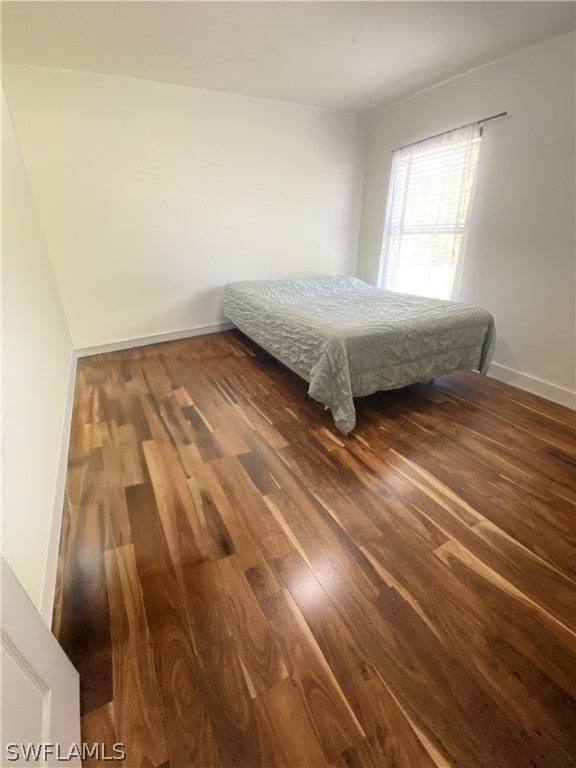 unfurnished bedroom with dark hardwood / wood-style flooring and billiards