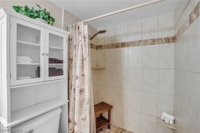 full bath with toilet and a tile shower