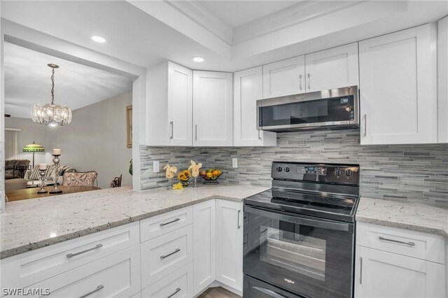 kitchen featuring decorative backsplash, light stone countertops, electric range, white cabinetry, and hanging light fixtures