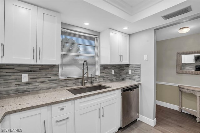 kitchen with tasteful backsplash, visible vents, wood finished floors, stainless steel appliances, and a sink