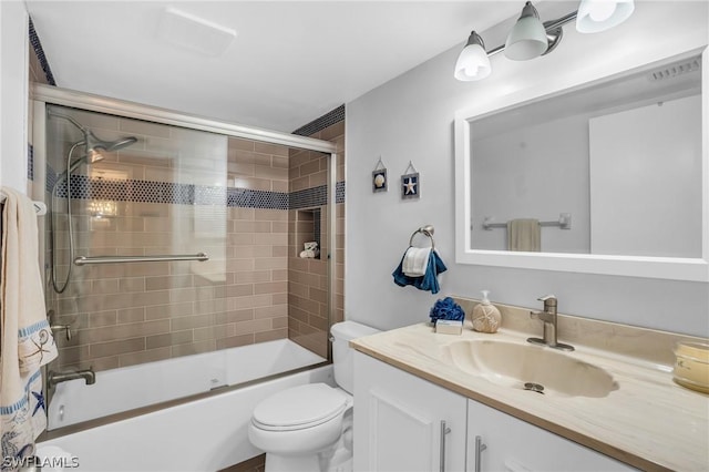 bathroom featuring visible vents, combined bath / shower with glass door, vanity, and toilet