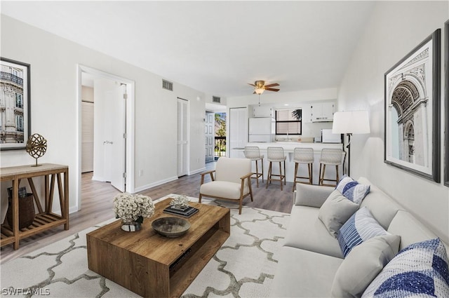 living room featuring ceiling fan and light hardwood / wood-style flooring