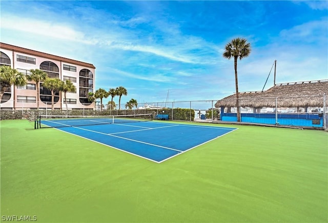 view of tennis court featuring basketball hoop