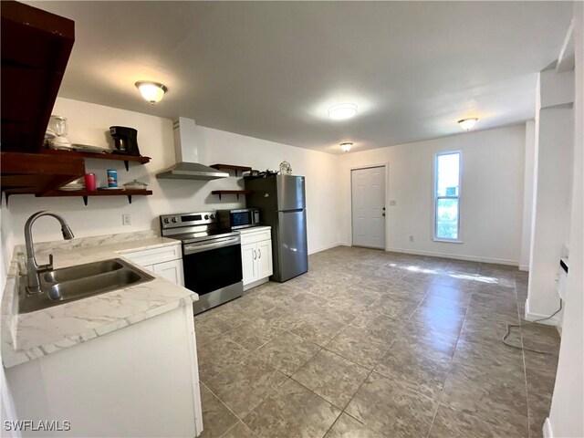 kitchen with stainless steel appliances, white cabinetry, wall chimney exhaust hood, and sink