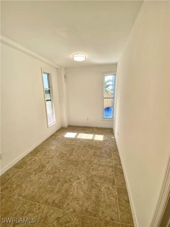 spare room with baseboards