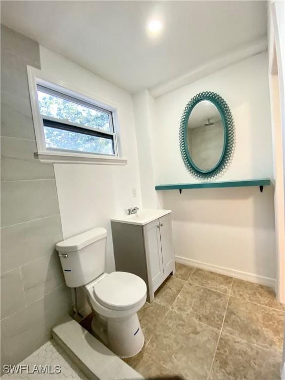 bathroom featuring toilet, vanity, and baseboards