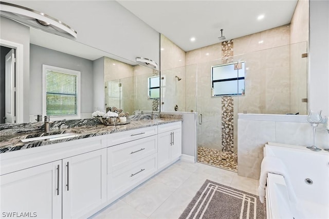 bathroom with plus walk in shower, vanity, and tile patterned floors