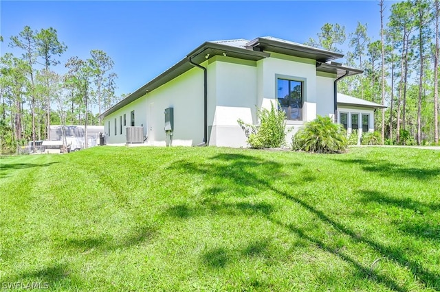 view of side of property with a lawn and cooling unit