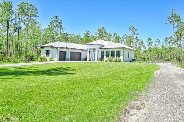 view of front of home featuring central air condition unit, a front yard, and a garage