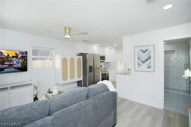 living room featuring ceiling fan and light wood-type flooring