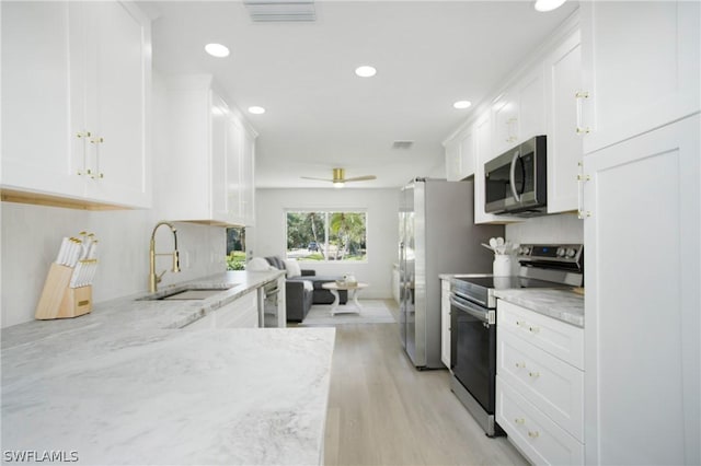 kitchen featuring light hardwood / wood-style floors, sink, white cabinetry, light stone countertops, and stainless steel appliances