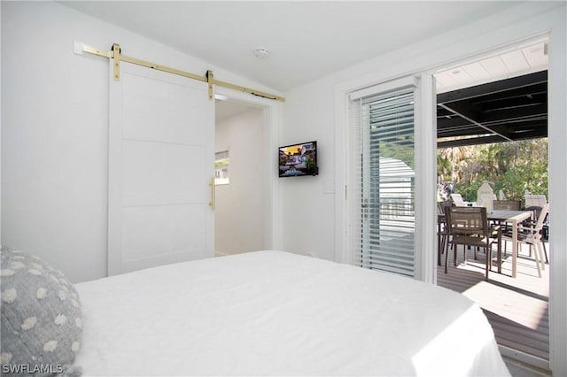 bedroom featuring vaulted ceiling, access to exterior, and a barn door