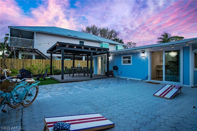 back house at dusk featuring a patio