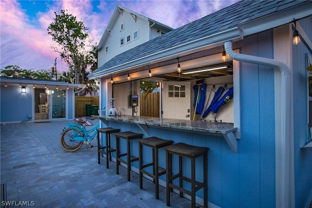 patio terrace at dusk featuring an outdoor bar