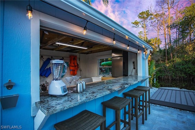 patio terrace at dusk featuring exterior bar