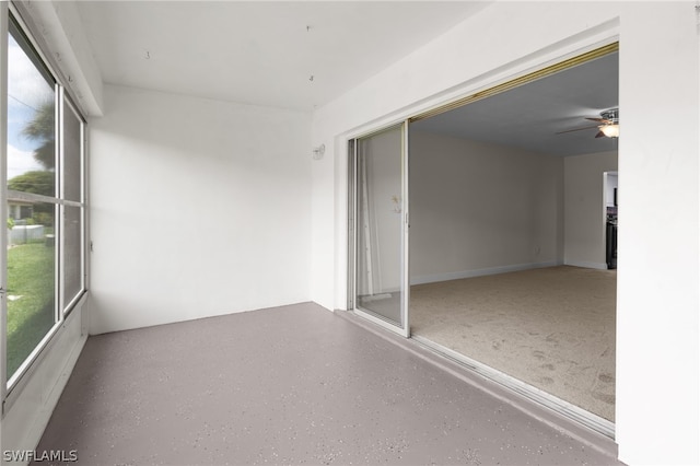 unfurnished sunroom featuring ceiling fan