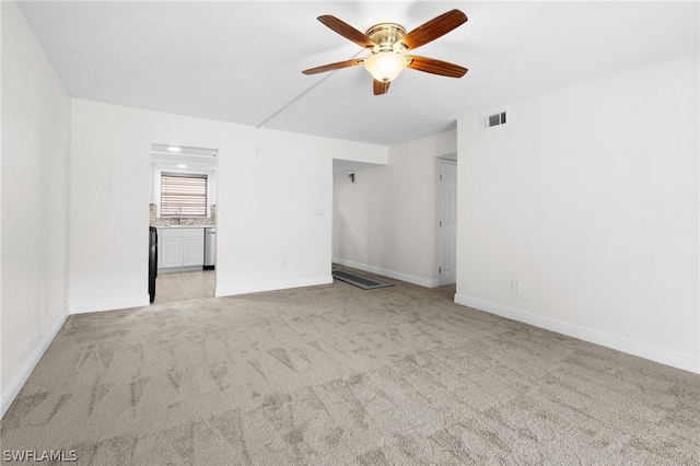 carpeted empty room featuring ceiling fan and sink