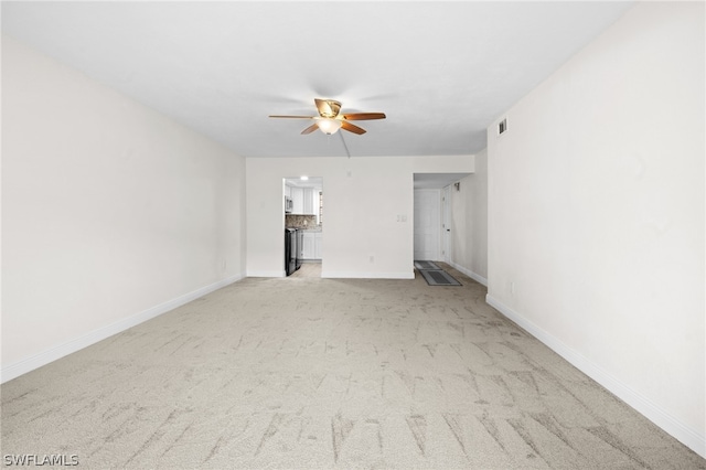 unfurnished living room featuring ceiling fan and light colored carpet