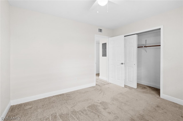 unfurnished bedroom featuring carpet flooring, a closet, electric panel, and ceiling fan