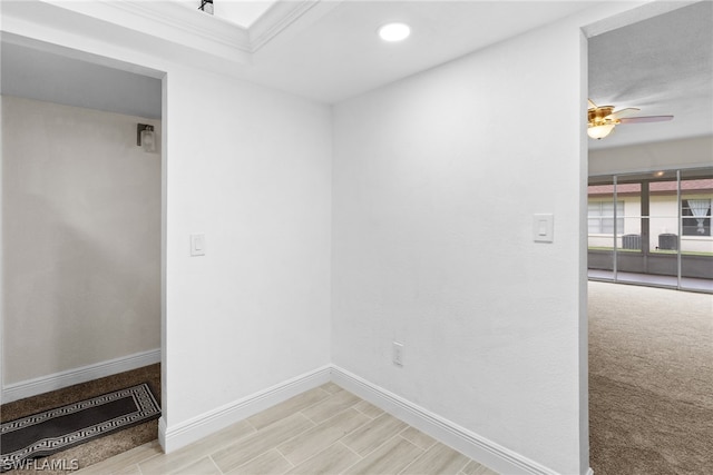 carpeted spare room with ceiling fan and ornamental molding