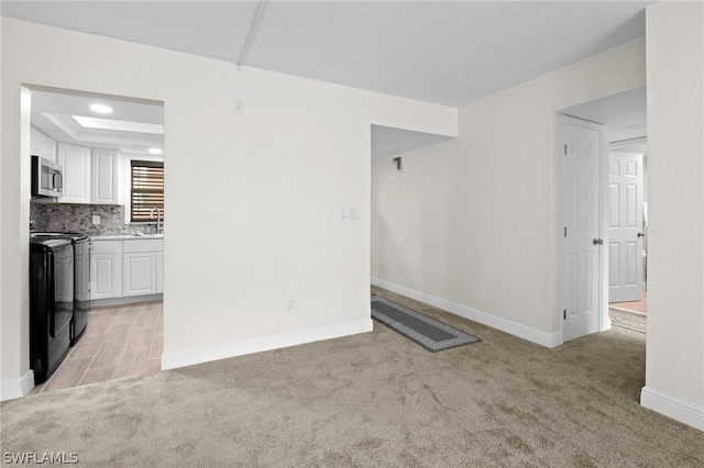 unfurnished living room with light colored carpet