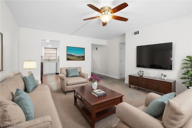 living room with ceiling fan and sink