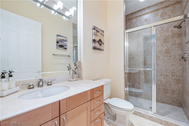 bathroom with vanity, toilet, a shower with door, and a notable chandelier