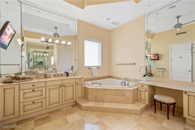 bathroom featuring tile patterned flooring, vanity, and tiled bath