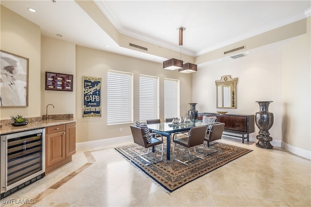 dining space featuring wine cooler, ornamental molding, and bar area