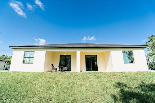 rear view of property with a yard and a patio