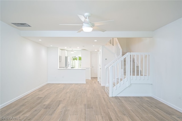 interior space featuring visible vents, baseboards, stairs, a ceiling fan, and light wood-type flooring